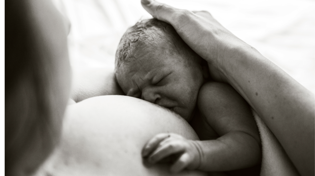 breastfeeding woman holding newborn baby to get a good latch