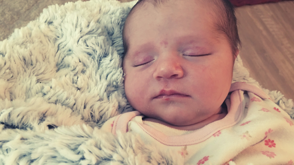 rainbow baby sleeping on fluffy gray blanket